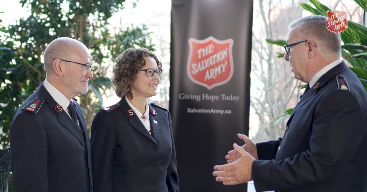 Three people face each other in conversation